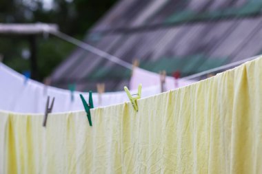 İpe asılı yeni yıkanmış çarşaflar. Kırsal alanda giysiler kuruyor..