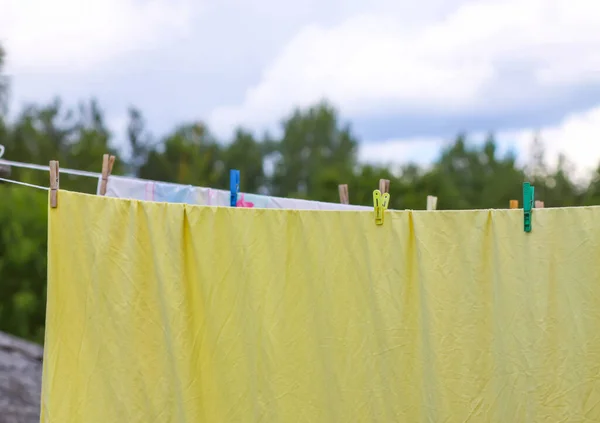ロープの上に吊るされた新しく洗われたベッドリネン 農村部の庭で衣類乾燥 — ストック写真