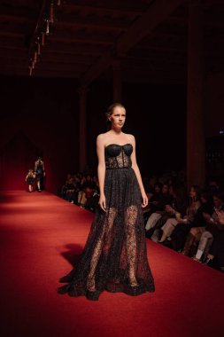 Astrakhan Rusya - 01 Kasım 2019. Caspian Moda Haftası. Bir kadın model kırmızı pistte yürüyor. Moda gösterisi, podyum yürüyüşü.