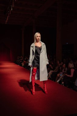 Astrakhan Rusya - 01 Kasım 2019. Caspian Moda Haftası. Bir kadın model kırmızı pistte yürüyor. Moda gösterisi, podyum yürüyüşü.