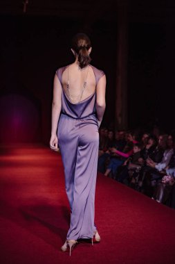 Astrakhan Rusya - 01 Kasım 2019. Caspian Moda Haftası. Bir kadın model kırmızı pistte yürüyor. Moda gösterisi, podyum yürüyüşü.