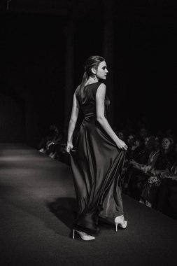 Astrakhan Rusya - 01 Kasım 2019. Caspian Moda Haftası. Bir kadın model kırmızı pistte yürüyor. Moda gösterisi, podyum yürüyüşü.