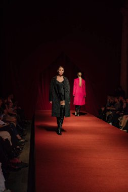 Astrakhan Rusya - 01 Kasım 2019. Caspian Moda Haftası. Bir kadın model kırmızı pistte yürüyor. Moda gösterisi, podyum yürüyüşü.