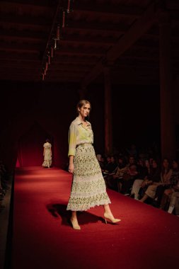 Astrakhan Rusya - 01 Kasım 2019. Caspian Moda Haftası. Bir kadın model kırmızı pistte yürüyor. Moda gösterisi, podyum yürüyüşü.