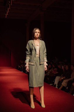 Astrakhan Rusya - 01 Kasım 2019. Caspian Moda Haftası. Bir kadın model kırmızı pistte yürüyor. Moda gösterisi, podyum yürüyüşü.