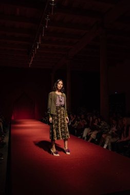 Astrakhan Rusya - 01 Kasım 2019. Caspian Moda Haftası. Bir kadın model kırmızı pistte yürüyor. Moda gösterisi, podyum yürüyüşü.