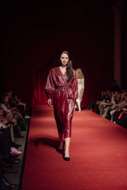 Astrakhan Rusya - 01 Kasım 2019. Caspian Moda Haftası. Bir kadın model kırmızı pistte yürüyor. Moda gösterisi, podyum yürüyüşü.