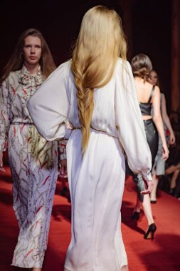 Astrakhan Rusya - 01 Kasım 2019. Caspian Moda Haftası. Bir kadın model kırmızı pistte yürüyor. Moda gösterisi, podyum yürüyüşü.