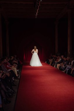 Astrakhan Rusya - 01 Kasım 2019. Hazar Moda Haftası. Beyaz gelinliklerle podyumda yürüyen kadın modeller.