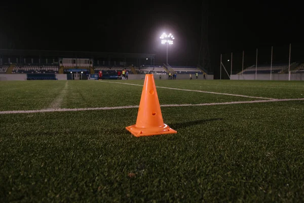 Orange cone for training football on the field