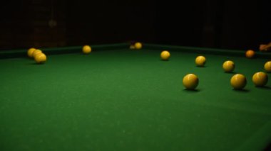 Beyaz gömlekli genç adam bilardo oynuyor..