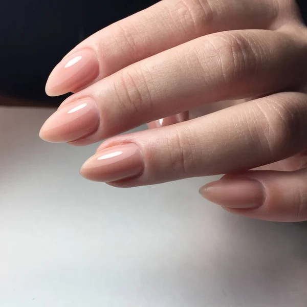 Manos femeninas con elegante manicura rosa sobre fondo blanco —  Fotos de Stock