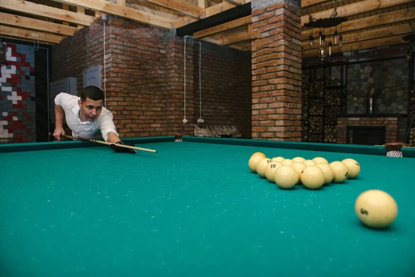 Joven jugando billar en el club de billar oscuro —  Fotos de Stock