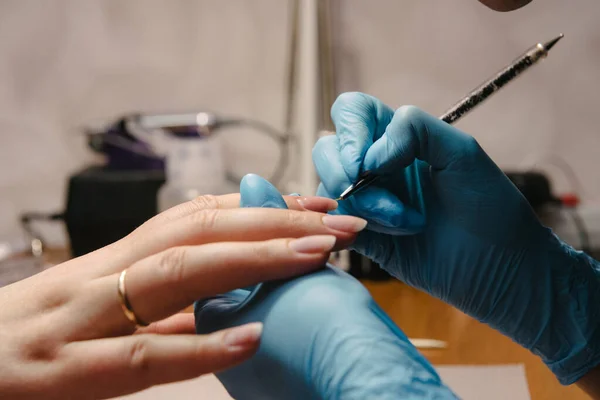 Manicurist makes hardware manicure close-up. Treatment of nails with the help of hardware manicure — Stock Photo, Image