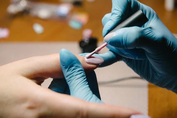 Manicurist makes hardware manicure close-up. Treatment of nails with the help of hardware manicure — Stock Photo, Image