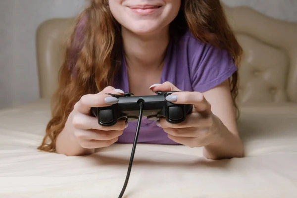 Dziewczyna gracz gra z gamepad patrząc na ekranie przed nią. — Zdjęcie stockowe