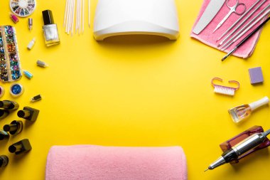 Sarı arka planda manikür ve pedikür ekipmanlarının üst görüntüsü