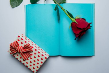 Not defterini aç, hediye kutusunu aç, beyaz arka planda gül ve kırmızı kalpler