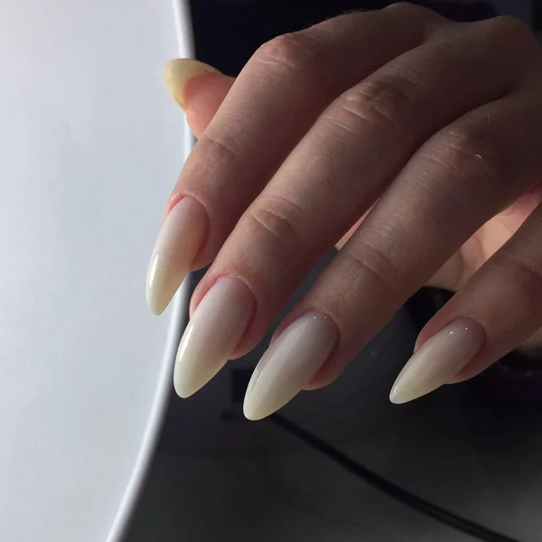 Manos femeninas con manicura beige de las mujeres en las uñas —  Fotos de Stock