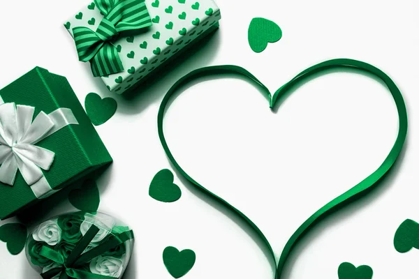 Corazón hecho de cinta verde brillante con cajas de regalo sobre un fondo blanco. Espacio libre para espacio de copia — Foto de Stock