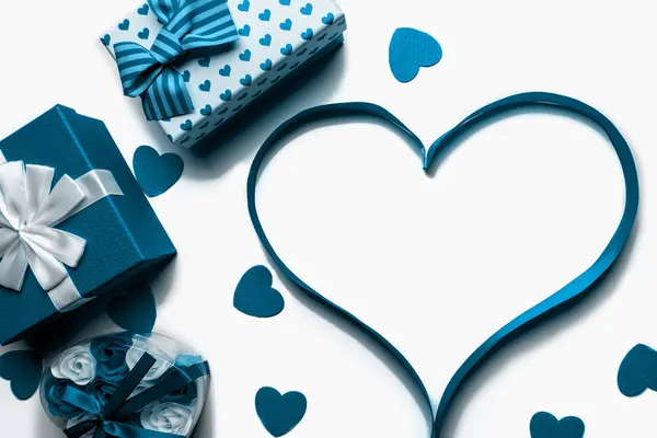 Corazón hecho de cinta azul brillante con cajas de regalo sobre un fondo blanco. Espacio libre para espacio de copia — Foto de Stock