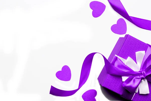 白い背景にリボンと心を持つ紫色のギフトボックス 孤立した画像 バレンタインデー 国際女性デーのコンセプト フラットレイアウト トップビュー — ストック写真
