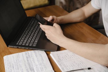 Tahta masadaki dizüstü bilgisayarda çalışan bir öğrenci. Mesafe öğreniyor.