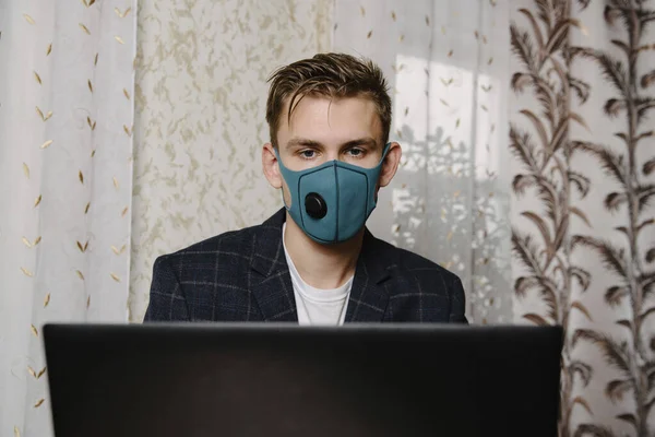 Man wear medical mask work with laptop. Avoid contact with other people. Stay home. Working from home. Online.