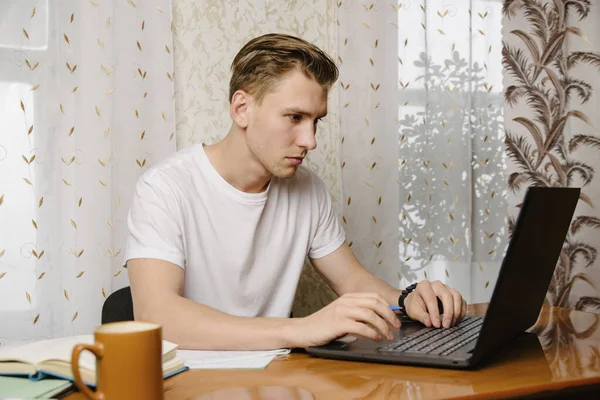 Joven Hace Tarea Cuaderno Trabaja Una Computadora Portátil Casa Escritorio — Foto de Stock