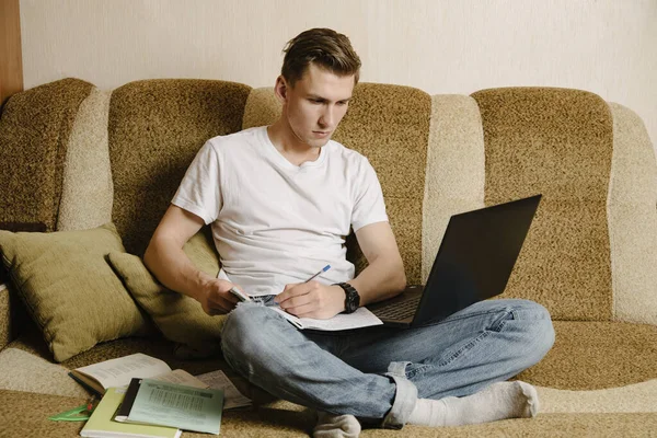 Joven Hace Tarea Cuaderno Trabaja Una Computadora Portátil Sillón Estudiante — Foto de Stock