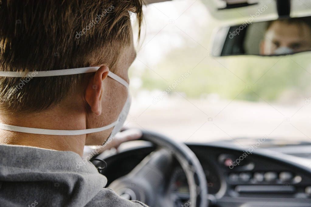 A man driving a car in a protective mask and gloves.Prevention of coronavirus infection.Protective measures against coronavirus, covid-19