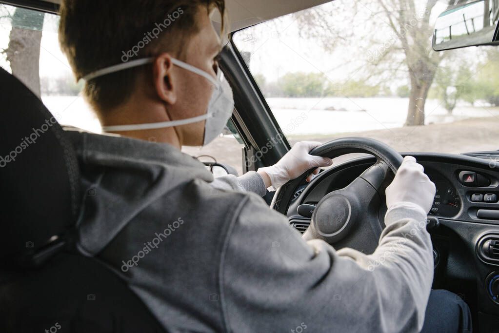 A man driving a car in a protective mask and gloves.Prevention of coronavirus infection.Protective measures against coronavirus, covid-19