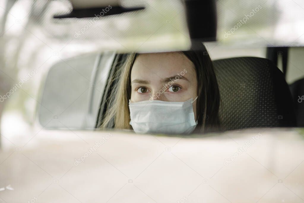 A woman driving a car in a protective mask and gloves.Prevention of coronavirus infection.Protective measures against coronavirus, covid-19