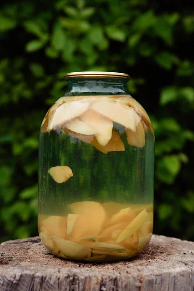 Canned quince fruit compote in a glass jar.Canned fruit compote against the background of nature.Organic homegrown produce