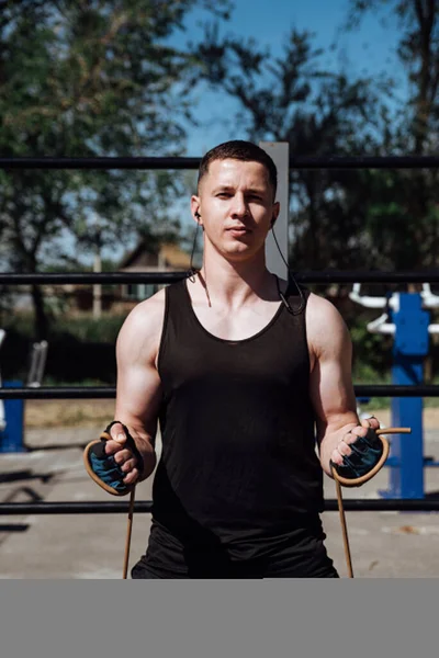 A young man trains with sport band in outdoor street gym.Workout lifestyle concept