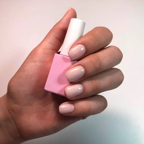 修指甲 漂亮的修指甲的女人的手与粉红指甲油 瓶装指甲油 时髦的粉色指甲油 — 图库照片