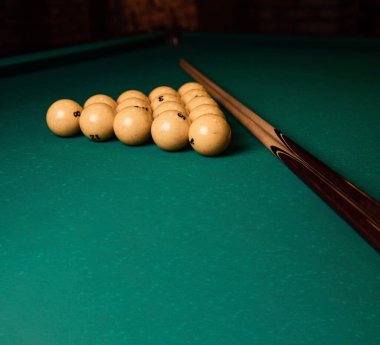 Bilardo sopaları ve yeşil bilardo masasında sarı bilardo topu piramidi. Toplu bilardo masası. Yakın plan.
