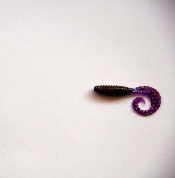 白い背景にシリコーンルアー 釣りを回転させるための紫色のプラスチック柔らかい餌 — ストック写真