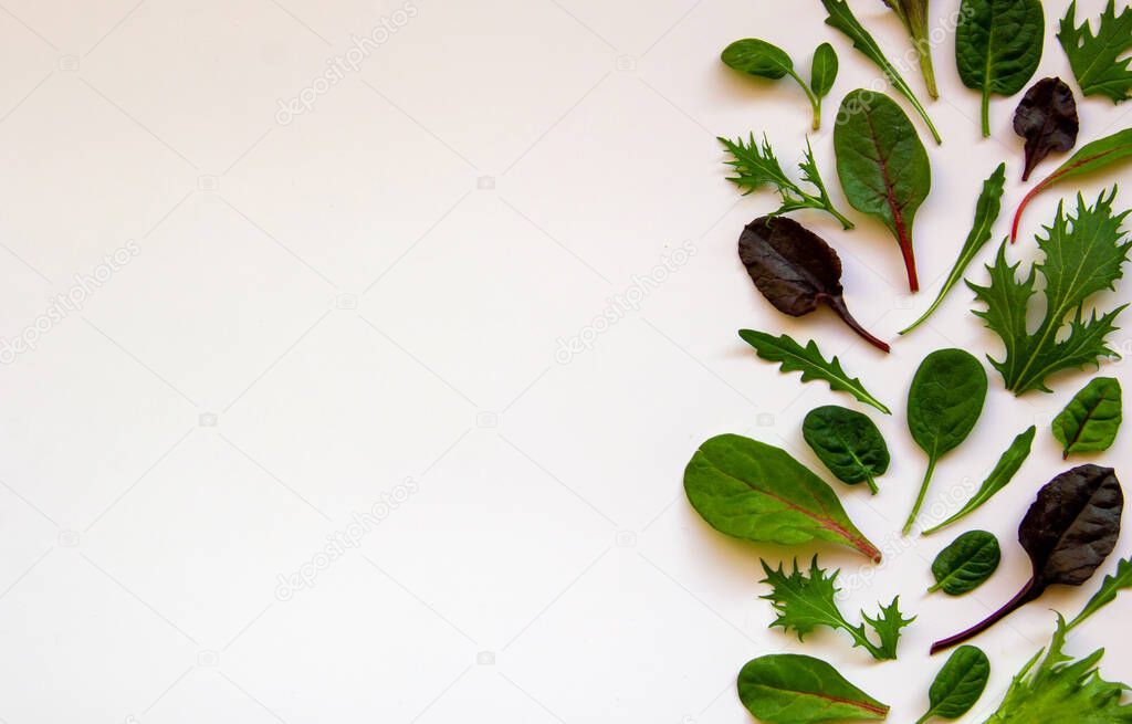Isolated mixed salad with arugula, mongold, spinach, lettuce on a white background. Baby leaves of vegetables.Healthy nutrition concept. Top view, flat lay, copy space.