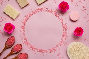 Pembe banyo tuzu, doğal sabun, duş süngeri, tahta kaşıklarda tuz, güller, pembe arka planda banyo bombası. Vücut bakımı konsepti, organik banyo ürünleri. Spa kozmetik. Düz yatıyordu. Boşluğu kopyala.