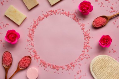 Pembe banyo tuzu, doğal sabun, duş süngeri, tahta kaşıklarda tuz, güller, pembe arka planda banyo bombası. Vücut bakımı konsepti, organik banyo ürünleri. Spa kozmetik. Düz yatıyordu. Boşluğu kopyala.