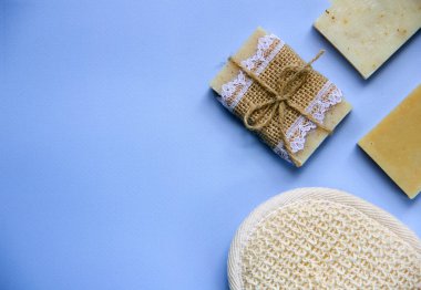 Doğal sabun, mavi arka planda banyo süngeri. Rahatlama, vücut bakımı, organik banyo ürünleri. Spa kozmetik. Düz yatıyordu. Boşluğu kopyala.