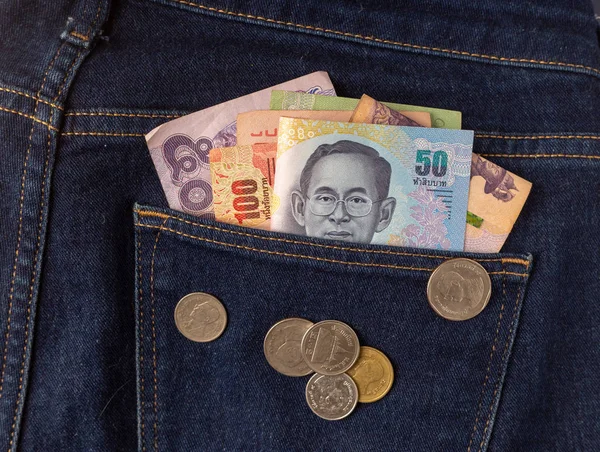 Arka cebinde üst görüntü olarak birçok baht banknot ve Tayland sikkesi bulunur.