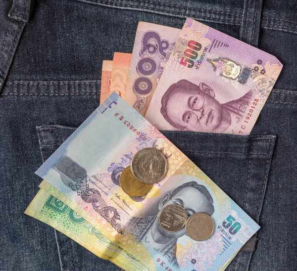Birçok baht banknot ve Tayland sikkeleri arka mavi kot pantolon cebinde üst görünüm yakın görüntü olarak