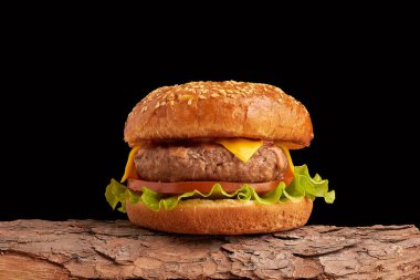 Siyah arka planda ev yapımı hamburger. Taze burger, ahşap kırsal masada. Çizburger..