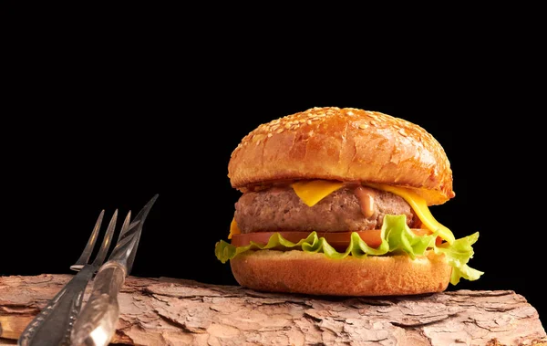 Siyah arka planda ev yapımı çizburger. Taze burger, ahşap kırsal masada. Hamburger..