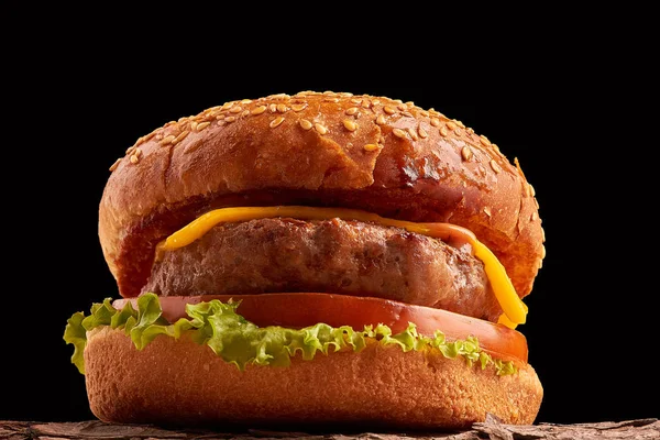Siyah arka planda ev yapımı hamburger. Taze burger, ahşap kırsal masada. Çizburger..