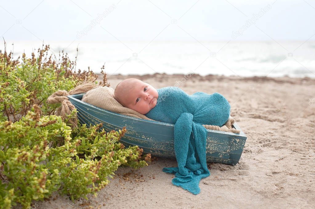Newborn Baby Boy Sleeping in a Tiny Boat