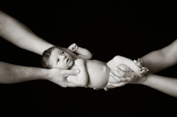 Bebé recién nacido sostenido por las manos de los padres — Foto de Stock