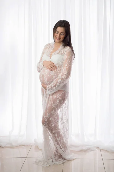 Smiling Pregnant Woman in a White Lace Gown — Stock Photo, Image